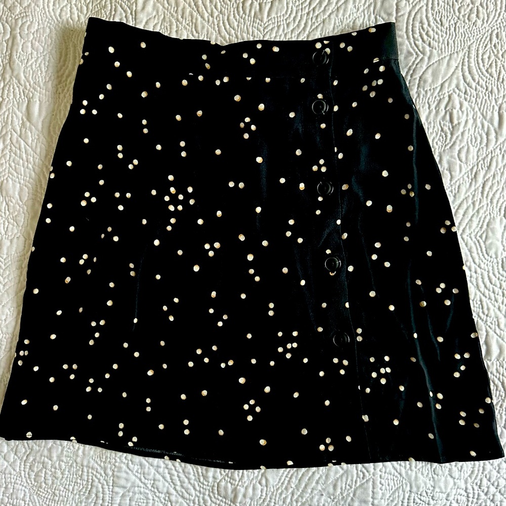 Chic black polka dotted mini skirt with vertically black buttons!